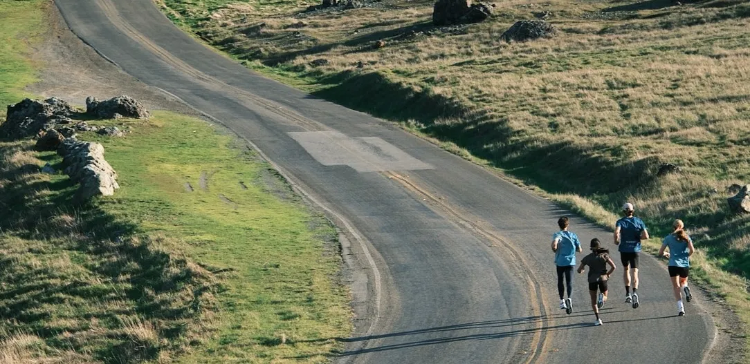 four people running on a street in Karhu shoes