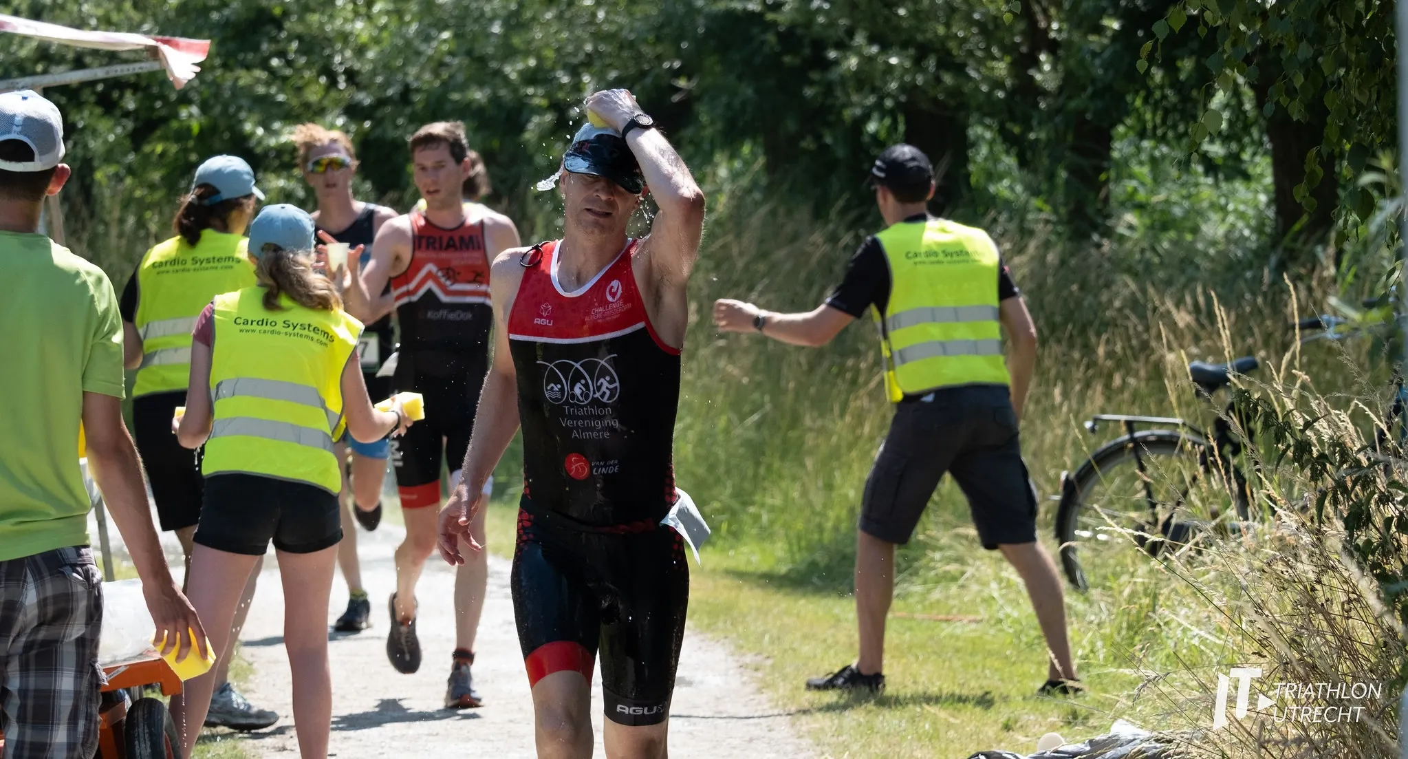 Runner grabbing a sponge from a bucket of ice water.